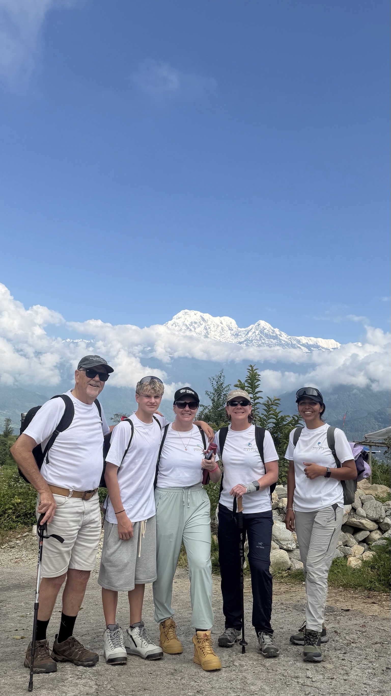 Sital with a trekking group and Himalayan peaks behind them